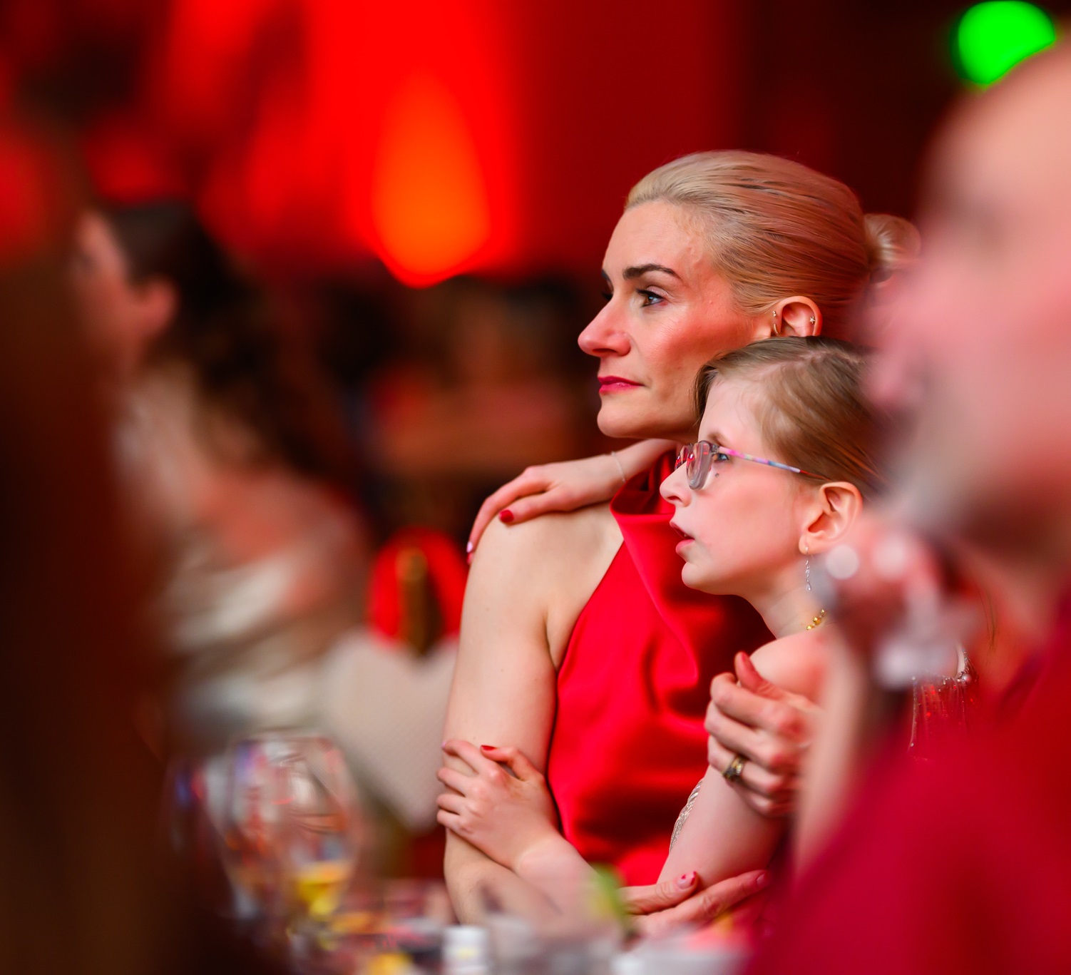 Woman with a little girl in her lap watching the Heart Ball program.